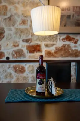 a bottle of wine sitting on a plate on a table at Villa Resi in Vamos