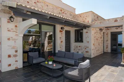 a patio with chairs and a couch and a table at Villa Resi in Vamos