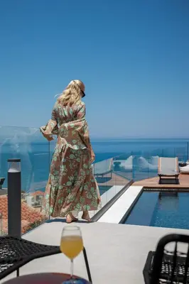 a woman is standing on the edge of a pool at Alectrona Living Crete, Villa Mezcal in Plataniás