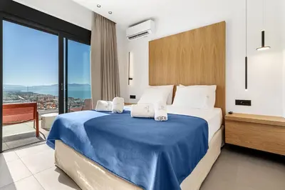 a bedroom with a large bed with a blue blanket at Alectrona Living Crete, Villa Mezcal in Plataniás