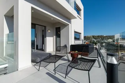 a group of chairs sitting on a balcony at Alectrona Living Crete, Villa Mezcal in Plataniás