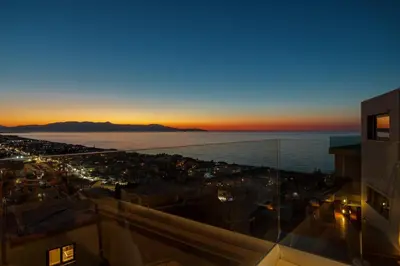 a view of a city at sunset from a building at Alectrona Living Crete, Villa Mezcal in Plataniás