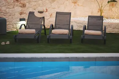 two chairs sitting next to a swimming pool at LUV Group of 4 Villas in Kathiana in Kathiana