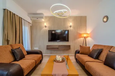 a living room with two brown couches and a tv at Helena's Dream Home in Maleme