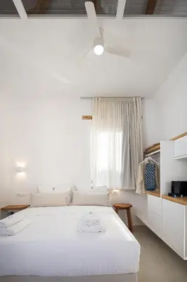 a white bedroom with a white bed and a window at Hub Hospitality in Chania Town