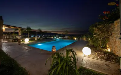 a swimming pool in a backyard at night at Villa Lady Dafni with private heated pool in Maleme