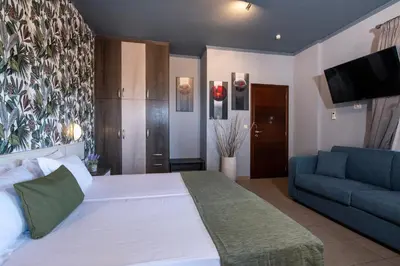 a bedroom with a large white bed and a couch at Villa Lady Dafni with private heated pool in Maleme