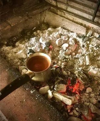 a cup of tea sitting on top of a fire at Mersini Village in Milonianá