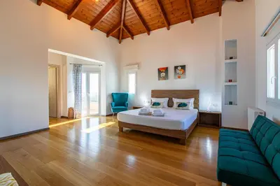 a large bedroom with a bed and a couch at Mystique Villa by Vintage Travel in Tavronitis