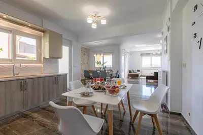 a kitchen and living room with a white table and chairs at Mystique Villa by Vintage Travel in Tavronitis
