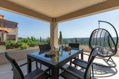 a table and chairs on a patio with a view at Mystique Villa by Vintage Travel in Tavronitis