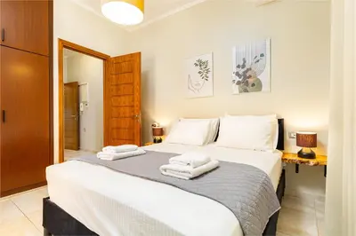a bedroom with a large bed with towels on it at Harbour - Spacious Unique 2-Balcony Apartment in Chania Old Town in Chania Town