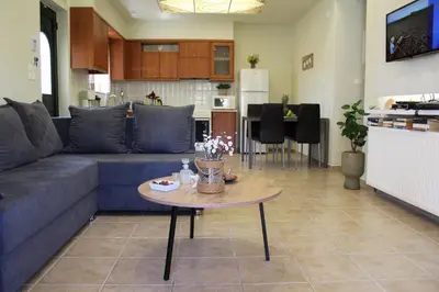 a living room with a blue couch and a table at Villa Alimedon in Almirida