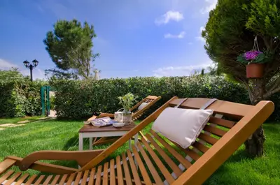 a wooden bench with a table in the grass at Villa Alimedon in Almirida