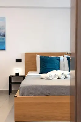 a bedroom with a large bed with blue pillows at A&G mare in Chania Town