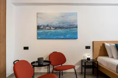 a bedroom with a bed and two chairs and a table at A&G mare in Chania Town