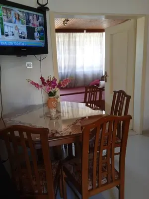 a dining room table with a vase of flowers on it at Marilu apartment in the center of Chania in Chania Town