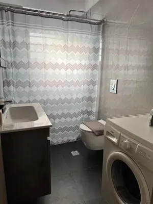 a bathroom with a toilet and a washing machine at Matthew's house in Kalamítsion Alexándrou
