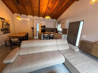 a living room with a large couch and a kitchen at Matthew's house in Kalamítsion Alexándrou