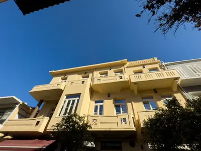 a tall yellow building with a sign on it at Deluxe Center Suites in Chania Town