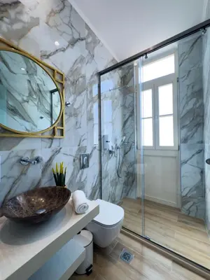a bathroom with a shower and a toilet and a sink at Deluxe Center Suites in Chania Town