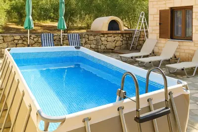 a swimming pool with chairs and a table and a pool at Chania's Diamond Villas - Aqua Bliss with Private Pools in Gavalochori