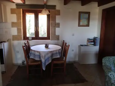 a kitchen with a table and chairs and a window at Apartment in natural stone house in Spiliá