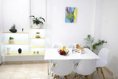 a white dining room with a white table and white chairs at Gardenia Maisonette Rooftop Old Town View in Chania Town