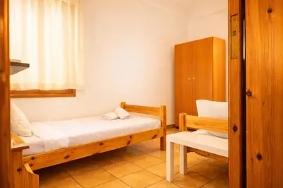 a small room with two beds and a chair at Gardenia Maisonette Rooftop Old Town View in Chania Town