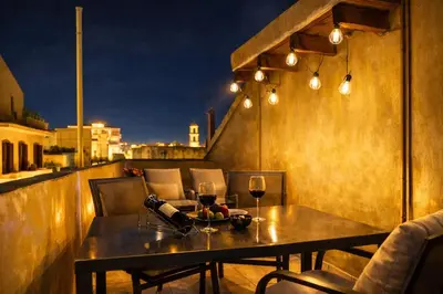 a table on a balcony with glasses of wine at Gardenia Maisonette Rooftop Old Town View in Chania Town