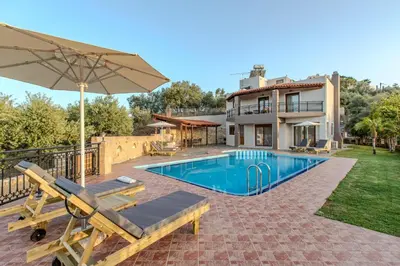a house with a swimming pool and an umbrella at Anna by Vintage Travel in Troúlous