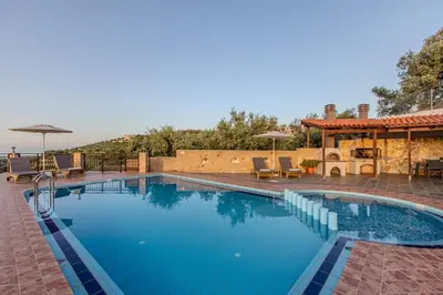 a pool with chairs and umbrellas on a patio at Anna by Vintage Travel in Troúlous