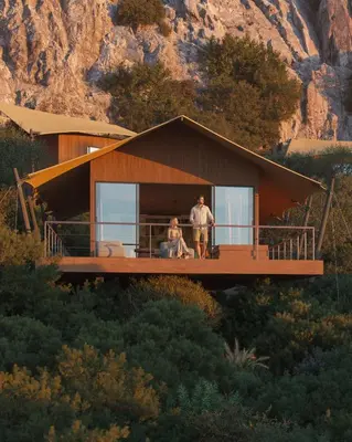 a man and woman standing on the balcony of a house at The Revery, Elafonisi - Member of Leading Hotels of the World in Livadia