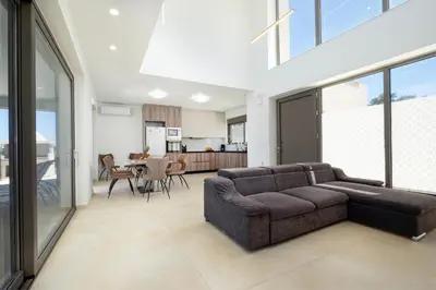 a living room with a couch and a kitchen at Villa Sea Breeze in Xamoudhokhórion