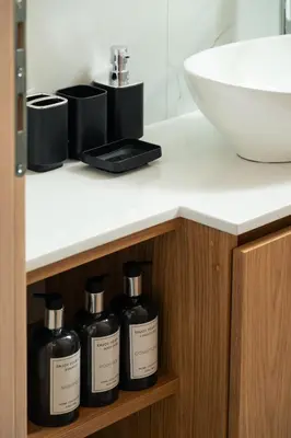 a bathroom counter with three bottles of soap and a sink at Ethea Residences-Helia in Chania Town