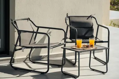 two chairs and two glasses of orange juice on a table at Ethea Residences-Orino in Chania Town