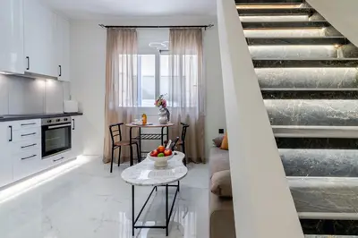 a living room with a staircase and a table at Peonia Apartment Modern Two-Level Stay Near Old Town in Chania Town