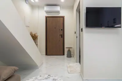 a hallway with a wooden door and a television at Peonia Apartment Modern Two-Level Stay Near Old Town in Chania Town