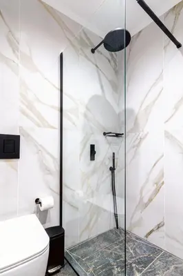 a shower with a glass door in a bathroom at Peonia Apartment Modern Two-Level Stay Near Old Town in Chania Town