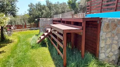 a wooden bench sitting on the side of a building at La Irilia Residences & Retreat in Agios Padeleimon