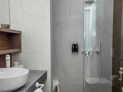 a bathroom with a glass shower and a sink at Amazing views in Chania Town