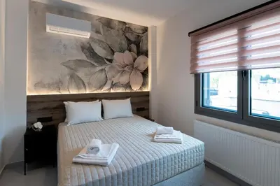 a bedroom with a bed and a painting on the wall at Lumera Urban Stay - New 2BR Home with Private Parking near Old Town in Chania Town