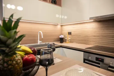 a kitchen with a bowl of fruit on a table at Lumera Urban Stay - New 2BR Home with Private Parking near Old Town in Chania Town