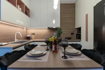 a kitchen with a wooden table with wine glasses at Lumera Urban Stay - New 2BR Home with Private Parking near Old Town in Chania Town