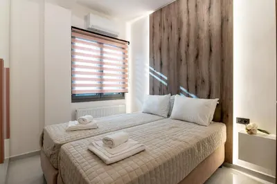 a bedroom with a bed with two towels on it at Lumera Urban Stay - New 2BR Home with Private Parking near Old Town in Chania Town