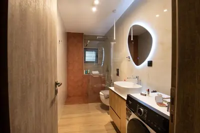 a bathroom with a sink and a toilet and a mirror at Lumera Urban Stay - New 2BR Home with Private Parking near Old Town in Chania Town