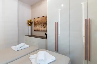 a bathroom with two beds with towels on them at Lumera Urban Stay - New 2BR Home with Private Parking near Old Town in Chania Town