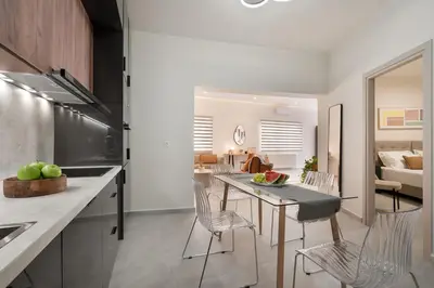 a kitchen and dining room with a table and chairs at Coralie 3 bedroom apartment 40m from the beach in Chania Town