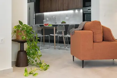 a living room with a couch and a kitchen at Coralie 3 bedroom apartment 40m from the beach in Chania Town