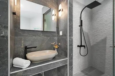 a bathroom with a sink and a mirror at Coralie 3 bedroom apartment 40m from the beach in Chania Town